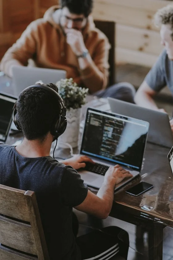Software team collaborating around a laptop